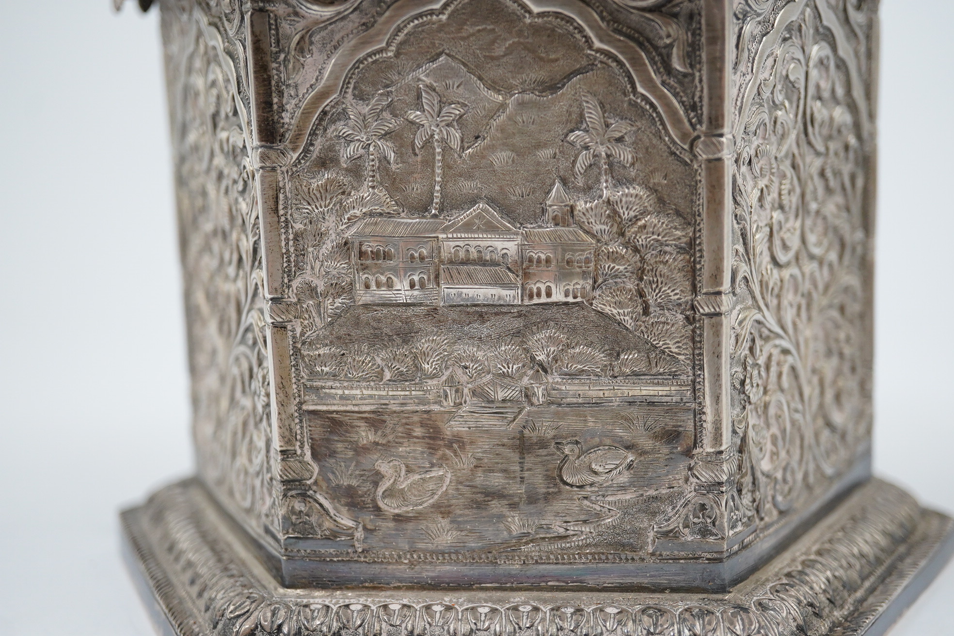 An early 20th century Indian embossed silver hexagonal box with fluted domed hinged cover